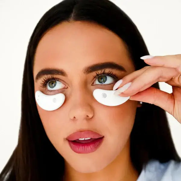 Femme utilisant des capsules oculaires blanches pour revitaliser ses yeux et soulager la fatigue oculaire.